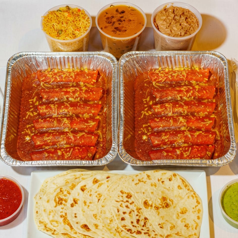 Indian meal spread with saucy enchiladas, rice, lentils, flatbreads, chutneys, salad, yogurt, and disposable utensils.
